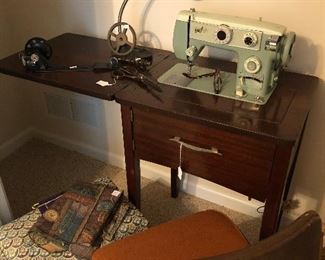 Older sewing machine and cabinet.