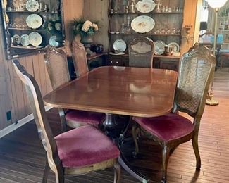 Banded dining room table with two leafs and six French country cane back chairs.