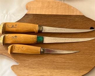 Two Wooden Fish Shaped Cutting Boards & J. Martini Filet Knives and one Rapala Knife. Items are in good/used condition with some wear/use. Please see all photos. 