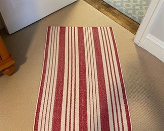 Red and white strip cotton rug. Measures 38" x 24".