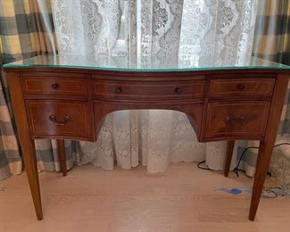 Serpentine front mahogany desk with glass top. Measures 44" W x 18.5" D. Photo 1 of 3.
