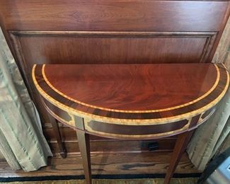 Pair of flame mahogany demi-lune tables with double satinwood banding. Each measures 35" W x 13.5" D x 29" H. Photo 1 of 3.