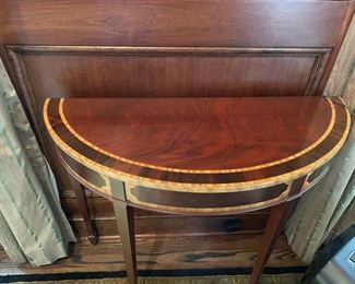 Pair of flame mahogany demi-lune tables with double satinwood banding. Each measures 35" W x 13.5" D x 29" H. Photo 2 of 3.