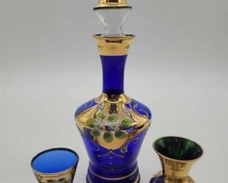 Follow the link to purchase:  https://serendipityatlanta.com/collections/virtual-estate-sale/products/bohemian-czech-cobalt-glass-decanter-cordial-w-gold-enamel-flowers-green-bud-vase-4e1d2