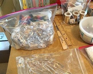 On the crafting table are two bags of glass prisms from an old chandelier.
