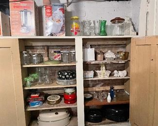 Basement cabinets full of vintage stuff. Old enamel turkey roaster on the bottom left.