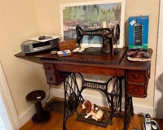 Vintage singer sewing machine in cabinet, Bose AM FM CD player, Radio Shack "walkie talkie",   Broderick Crawford Hall’s & Harvey’s print. 