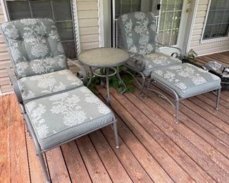 Metal chairs with matching foot rest, round glass top table.