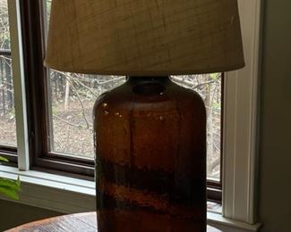 Pair of jug-style amber glass table lamps with natural fiber shades. Photo 1 of 2.