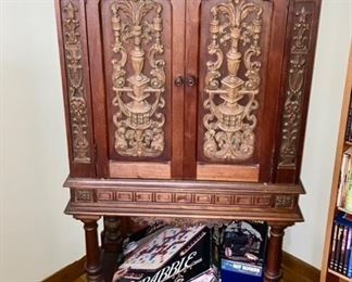 Antique record cabinet repurposed to a storage cabinet with shelf, games