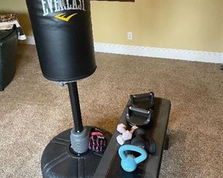 Everlast punching bag, weight bench, and misc. free weights