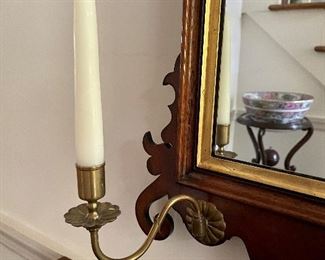 Brass candle sconces on mirror