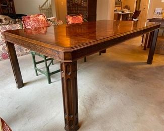 Burl wood extension table with fretwork trim. Measures 62" L  x 44" W x 30" H; extends to 104" W with two 21" Leaf.  26" clearance. Photo 1 of 5. 