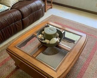 Wood and glass coffee table, area rug, household decorations