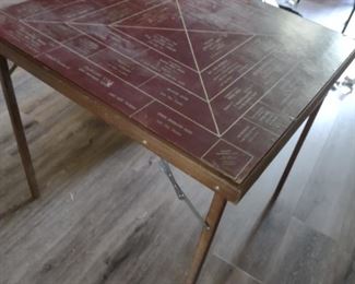 Antique folding table with monopoly-like theme of Lake City FL businesses. 