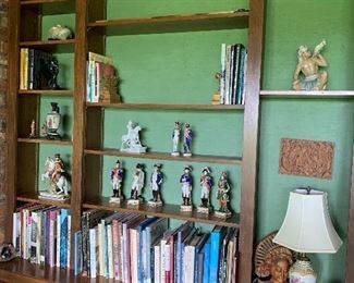 Books, bookends, carved pieces, lamp, impressive grouping of European figures, china bits