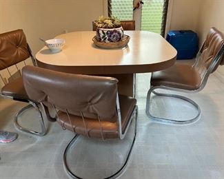 1980's era table with big column base and chrome leg vinyl upholstered chairs