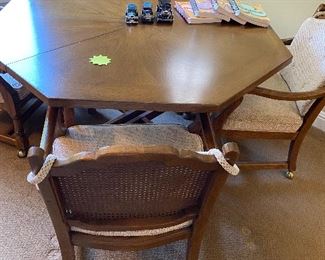 octagon games table with two leaves along with four castored chairs 