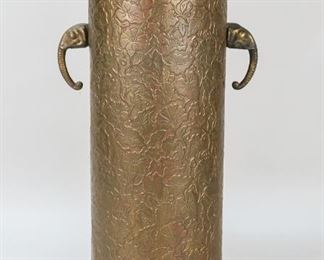 8	Figural Brass Stand	"Brass figural stand. Decorated with elephant heads and flower incised decoration on sides. Top with two allegorical faces in relief. 20 1/2"" H x 11"" top diameter. Wear to metal.
"
