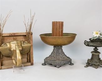 11	Grouping of Metal Decorative Accessories	"Grouping of metal decorative accessories. 20th Century. A brass elephant head in a wood frame, and two Victorian metal planters, one with a metal painted flower, the other supporting a brass dish. Heavy wear and oxidation to flower planter.
Largest item in group: 14"" H x 11"" L x 5"" D
"
