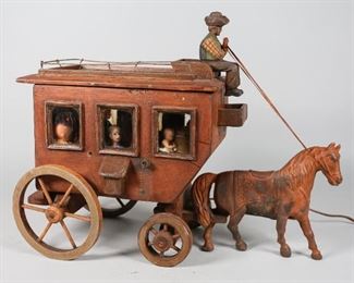 26	Folk Art Wooden Horse and Carriage Lamp	"Folk art wooden horse and carriage table lamp with figurines inside carriage windows and flickering light. Losses and wear throughout.
15"" H x 20"" L x 8"" W."
