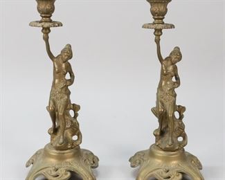 64	Pair of Art Nouveau Figural Brass Candlesticks	Pair of art nouveau figural brass candlesticks. Marked M.D. on the underside. 5 1/4" L x 5 1/4" W x 12 1/2" H. Crazing to the material by figure's necks, residue to the interior of candleholder.
