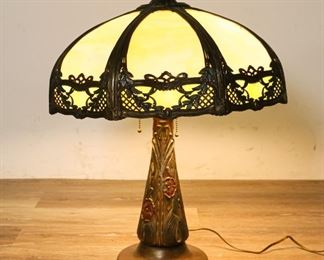65	Art Nouveau Slag Glass Table Lamp	"Art Nouveau slag glass table lamp, with hand painted brass tone floral pattern lamp base, eight-panel slag glass shade. Paint loss to lamp base.
24"" H x 8 1/2"" Base diameter."
