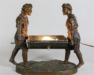 77	Arabian White Metal Figure Group	Austrian style Arabian white metal figure group of two men. With later paint decoration and light. Unsigned. 12"H x 13 1/4"L. Paint loss and scratches throughout; original piece missing from hands and replaced, with hands re-drilled and repaired.
