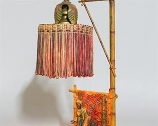 79	Austrian Cold Painted Bronze Lamp	Austrian cold painted bronze lamp, in the style of Franz Bergman. Marked Made in Austria on the underside. 14 1/4"H x 6"W x 4"D. Wear and paint loss to rugs, faux bamboo and top of shade.

