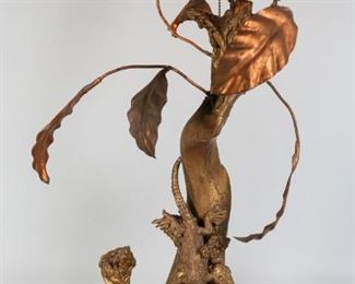 82	Figural Gilt Painted Wood & Metal Lizard Lamp	Figural gilt painted driftwood and metal lamp. Gilt painted and embellished tree branch wooden lamp base, with applied carved wood and composition lizards and metal leaf decorations. 30"H x 11 1/2"W. Scratches and losses to gilt decoration throughout, chip to plug.
