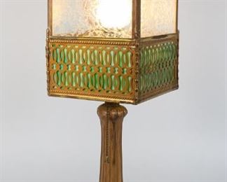 86	Slag Glass Lantern Lamp	Gilt painted B & H style metal lamp base, with slag and etched glass lantern form shade. 23 1/4"H with finial. Losses and wear to gilt decoration on base, losses to metal on shade, metal decoration on shade cracked and separating from shade, shade and finial sit slightly crooked on base.
