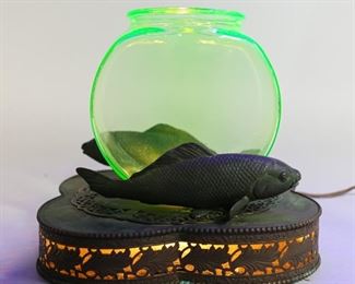 87	Uranium Glass & Brass Light Up Fishbowl	Uranium glass fishbowl on figural fish form patinated brass base. 7 1/2"H x 8"W x 8"L. Some oxidation to base. With working light in base.
