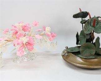 88	2 Floral Center Pieces	2 floral center pieces. 1 bronze dish with handle and painted metal flowers. Pressed glass tree with flowers on rock glass base. Bronze and metal centerpiece: 13 1/2" H x 14 1/2" base diameter. Loss to 2 flowers. Wear to wire around tree limbs. Later painting to metal flowers. Loss to paint of metal flowers.
