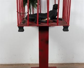 97	Caged Beast Diorama	Caged beast diorama. Composite beast reminiscent of a big cat with glass eyes, sculpted meat and bone. Acrylic plant with clay base. Assembled wood cage on a pedestal. Motion activated light installed to the top of the cage. Pedestal: 17 1/4" L x 17 1/4" W x 34 1/4" H. Cage: 24" L x 24" W x 19 3/4" H.
