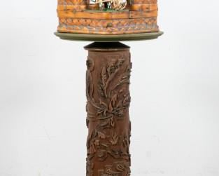 104	Found Object Lamp	Found object lamp. Carved wood stand with inlaid metal floral motif. Found object scene with woven basket homes, faux ivory figures. Acrylic hanging lantern and plant. Brass fixture with 1 light. 8 1/2" L x 8 1/2" W x 55" H. Cracks to the wood stand, loss to the metal inlay. Light flickers when turned on.
