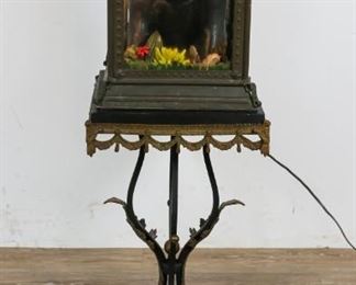 108	Gorilla Diorama on Neo Classical Stand	Painted wood gorilla diorama with metal and acrylic flowers, patinated brass box with glass panels, figural art nouveau style lid. Neoclassical style iron stand with stone top. Claw feet with brass appliques. 13" L x 13" W x 38 1/2" H. Scuffs to the stone table top. Scuffs to the metal art nouveau case.
