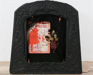109	Macabre Devil Outsider Art Piece	"Macabre devil outsider art piece. American, 20th Century. Mixed media consisting of carved black frame housing a music sheet cover titled ""At the Devil's Ball"", black veil, four flickering lights, and a Mephistopheles, style devil supporting skull and flowers. Sheet music from which cover was taken from taped to back of verso. Illumination tested and in working order. Some wear to lower left of frame. 

30"" x 27"""
