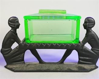 116	Art Deco Uranium Glass Cigarette Box	Art Deco uranium glass cigarette box. Marked on the interior 226 Pipo. 7" L x 4 1/2" H. Glass box: 4" L x 3" W x 2 1/2" H. Bubbles to glass. Scuffing to the underside of the box.
