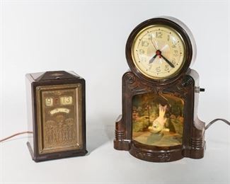 136	2 Early 20th Century Clocks	2 clocks: General Electric Bakelite executive clock. Engraved metal front panel. Model number AB8B02. Master Crafters clock model no. 335, Swinging Bird. Plastic body with metal back plate. Lithographed background. Mastercrafters clock: 7" L x  5" W x 10" H. Mastercrafters clock in working condition.
