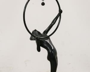 145	Frankart Figural Lamp with Amber Glass Shade	Frankart painted metal figural lamp with amber glass shade. Female nude holding a hoop upon a skyscraper base. Circa 1930. 10 1/2" L x 10 1/2" W x 33"H. Figure mounted on a new base. Paint restorations to the body. Originally a smoke stand, now electrified.
