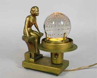 146	Art Deco Nuart Lamp with Control Bubble Glass	Art Deco Nuart metal painted figural lamp with control bubble glass. Marked on the base Nuart Creations NYC. 5" L x 3" W x 7" H. Wear to paint throughout the lamp stand.

