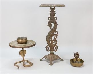 167	2 Metal Figural Stands	"Patinated brass cobra stand with tray and bowl. Iron nautical stand. Additionally, a brass bell with compass and wood model ships wheel. Nautical stand: 20"" H. Rust present to the nautical stand. Repair to brass cobra. 

"
