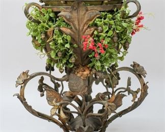 168	Iron Victorian Garden Planter Bank	Iron Victorian garden planter bank. With coin slot on top. 16 1/2" H. Rust to top of lid. Loss to patina throughout. Later added acrylic plants with metal acorn ornaments.
