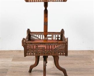 170	2 Tiered Upholstered Sewing Stand	Fretwork wood sewing stand with spool holder in the top panel. 2 tiers. Stamped on the underside, Pat. Aug 31 '86. 12 1/2" L x 12 1/2" W x 32 1/2" H. Cracks to wood paneling. Loss to joinery on bottom stand. Cracks to joinery on top stand. Wear to numbering on hang tags. Loss to fabric, bottom stand. Additionally: Belding Hemingway sewing silk case with spools mostly full, J&P Coats paper box with mending silk spools, mostly full.
