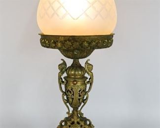 175	Renaissance Revival Gilt Bronze Figural Lamp	Renaissance revival gilt brass figural oil lamp, drilled and electrified. Frosted glass shade. Marked on the base, FC. 9 1/4" L x 5 1/2" W x 27" H. Paint restorations to top and bottom of openwork urn.
