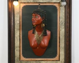 176	Egyptian Revival Bust in Frame	Egyptian Revival polychrome bust, beaded metal headdress, metal earrings and dangle necklace. Mounted on wood panel. Composite painted frame. 2 ball lights in upper left and right. Bust: 6" W x 13" L x 27 1/2" H. Frame: 45 1/4" x 34". Minor wear to paint on edges of frame.
