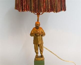180	Chinese Figural Lamp	Paint metal figure on pedestal, man eating rice under a lamp post. Marquetry shade with tassels and lamp post finial. 22" H x 10 1/2" shade diameter. Wear to paint on figure. Pedestal loose on base.
