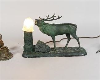 182	Moose Table Lamp, Buffalo & Stag Inkwells	Painted composite table lamp with bronze moose. Painted metal buffalo inkwell. Silvered pewter inkwell with antlers and stag head. Moose lamp: 11" L x  3 3/4" W x 6 3/4" H. Repair to 1 antler of stag inkwell. Repairs to antlers of stag head. Wear to paint on metal.
