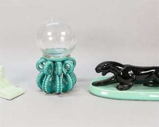185	3 Piece Figural Pottery Grouping	3 piece figural pottery grouping. Haeger pottery black stalking panther, mounted on a green pottery base, base signed Haeger on the underside, 13"L including base; unsigned sphinx pottery ashtray, 9"L; unsigned crackle glaze pottery octopus stand with glass fishbowl, 10 1/4"H. Drill holes in base of Haeger panther, losses and wear to octopus on top rim and bottoms of tentacles.
