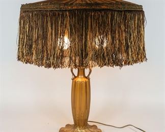 184	Art Nouveau Patinated Metal Table Lamp	Art Nouveau patinated metal table lamp. Brown fabric shade with brown and gold tassels. 2 lights and 2 metal pull chains. 24 1/2" H (from base to lamp finial) x 19" shade diameter. Wear to paint on lamp base. Fabric is worn on shade, some tassels missing. Wear to interior lining of fabric.
